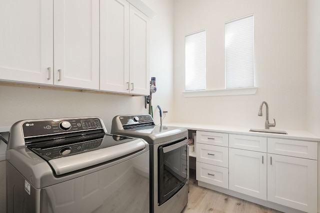 20704 Leaning Oak Dr, Lago Vista, TX 78645 - laundry room featuring washing machine and clothes dryer, cabinet space, and light wood finished floors