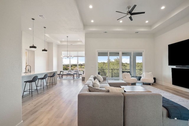 20704 Leaning Oak Dr, Lago Vista, TX 78645 - living area with a raised ceiling, light wood-style flooring, recessed lighting, a towering ceiling, and a chandelier