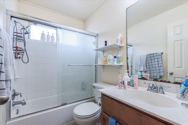 bathroom with vanity, toilet, and combined bath / shower with glass door