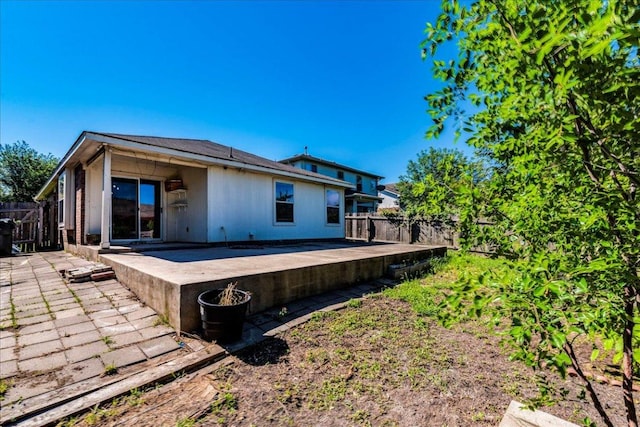 rear view of property featuring a patio and a fenced backyard