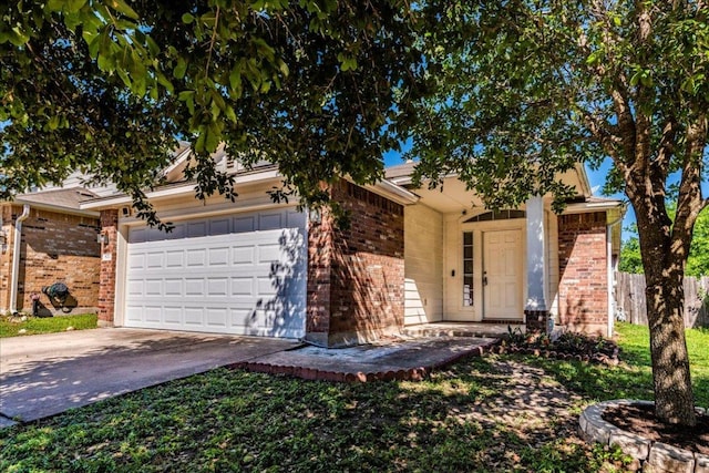 view of property hidden behind natural elements with brick siding, an attached garage, driveway, and fence