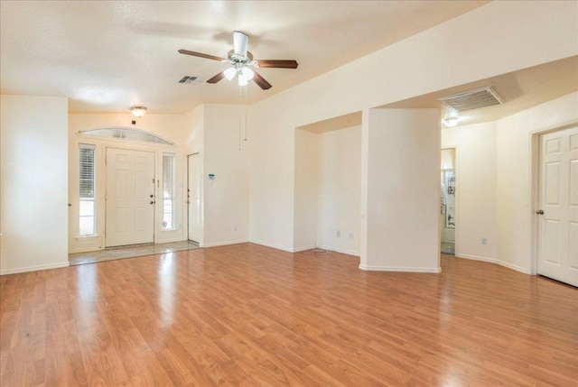 unfurnished living room with ceiling fan, light wood-style flooring, and baseboards