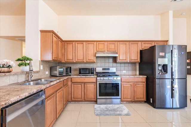 821 Sweet Leaf Ln, Pflugerville, TX 78660 - kitchen with stainless steel appliances, under cabinet range hood, backsplash, and light countertops