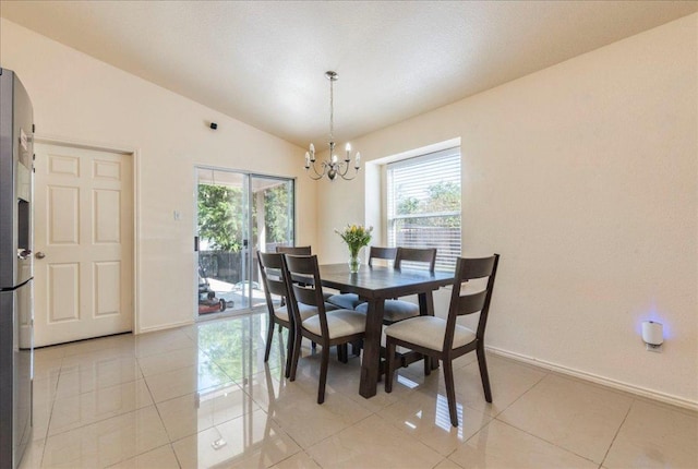 dining space featuring a chandelier, lofted ceiling, baseboards, and light tile patterned floors