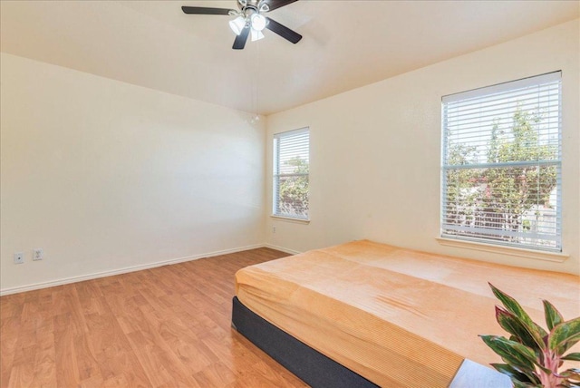 bedroom with light wood-type flooring, baseboards, and a ceiling fan