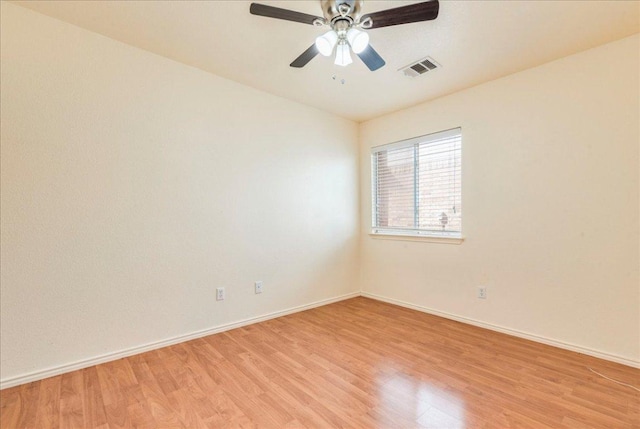 spare room featuring light wood-type flooring, baseboards, and a ceiling fan