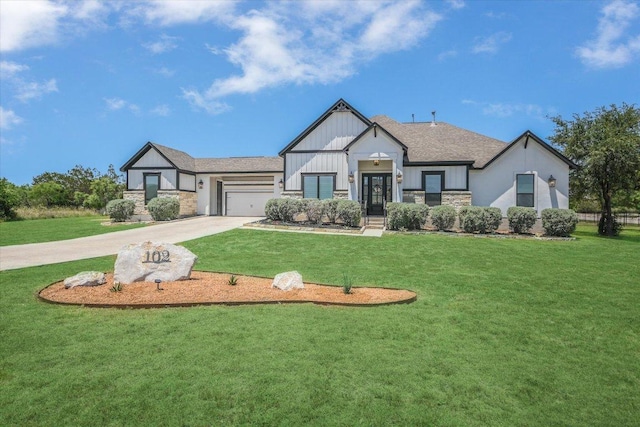 view of front of home featuring stone siding, a garage, driveway, and a front lawn