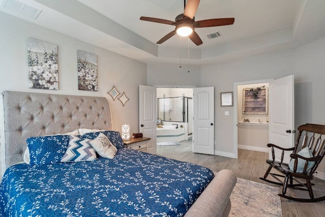 512 Bell Boot Pass, Georgetown, TX 78626 - bedroom with a raised ceiling, connected bathroom, wood finished floors, and baseboards
