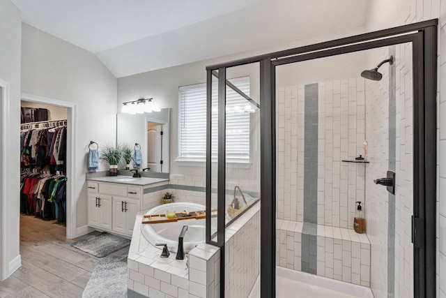 512 Bell Boot Pass, Georgetown, TX 78626 - full bath featuring a stall shower, a bath, vaulted ceiling, vanity, and wood finished floors