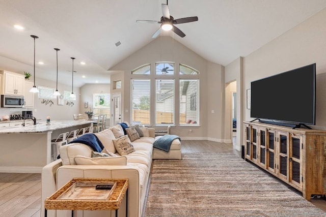 512 Bell Boot Pass, Georgetown, TX 78626 - living room with light wood-type flooring, ceiling fan, recessed lighting, baseboards, and high vaulted ceiling