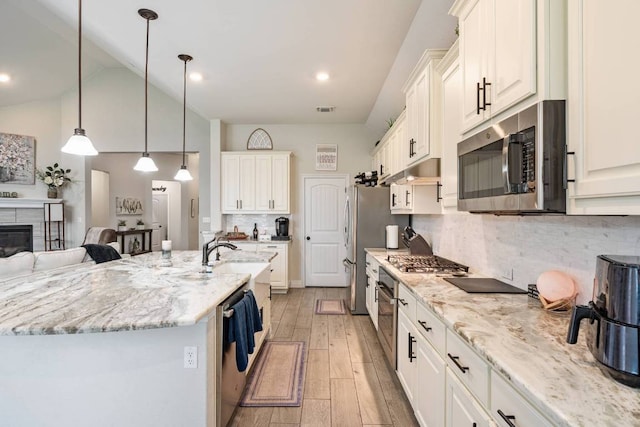 512 Bell Boot Pass, Georgetown, TX 78626 - kitchen with stainless steel appliances, light stone counters, light wood finished floors, a sink, and tasteful backsplash