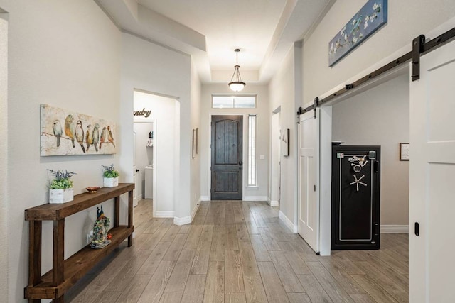 512 Bell Boot Pass, Georgetown, TX 78626 - foyer entrance featuring a barn door, light wood-style floors, baseboards, and washer / clothes dryer