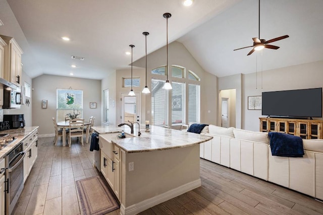 512 Bell Boot Pass, Georgetown, TX 78626 - kitchen with appliances with stainless steel finishes, light wood-style flooring, open floor plan, a ceiling fan, and baseboards