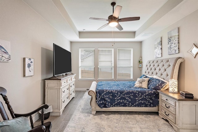 512 Bell Boot Pass, Georgetown, TX 78626 - bedroom featuring a tray ceiling, light wood-type flooring, baseboards, and a ceiling fan