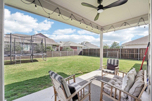 view of patio / terrace featuring a trampoline, ceiling fan, an outdoor living space, and a residential view