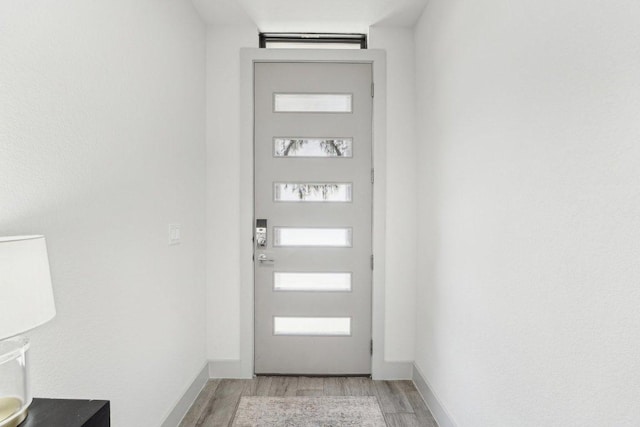 doorway to outside featuring light wood-style floors and baseboards
