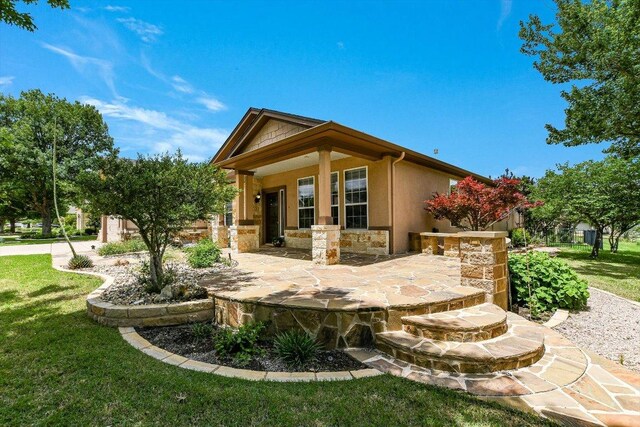 214 Yellow Rose Trl SE, Georgetown, TX 78633 - rear view of house with stucco siding, stone siding, and a yard