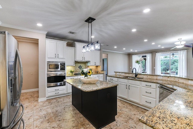 214 Yellow Rose Trl SE, Georgetown, TX 78633 - kitchen with stainless steel appliances, a sink, ornamental molding, a kitchen island, and tasteful backsplash