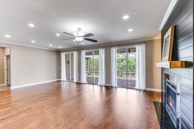 214 Yellow Rose Trl SE, Georgetown, TX 78633 - unfurnished living room with crown molding, a fireplace, baseboards, ceiling fan, and wood finished floors
