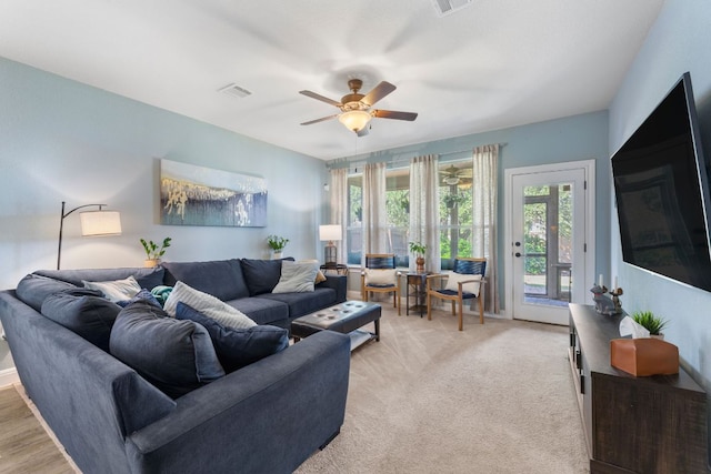 living area featuring healthy amount of natural light and ceiling fan