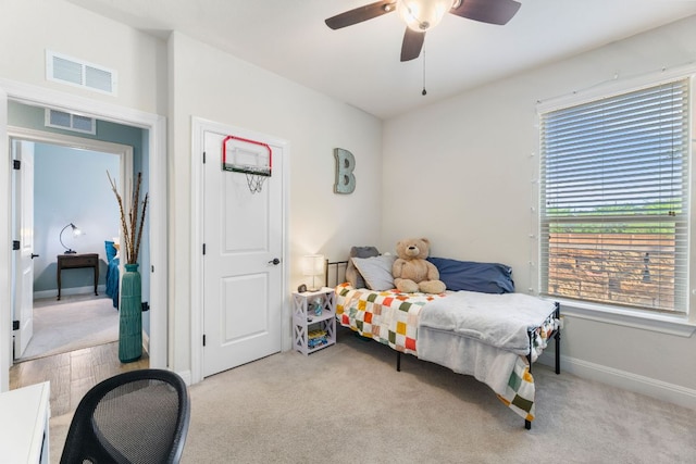 carpeted bedroom with ceiling fan and baseboards
