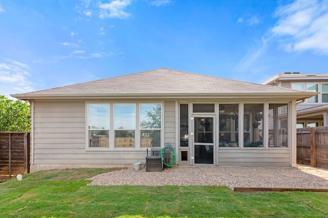 rear view of house featuring a sunroom and roof with shingles