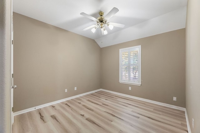 spare room with light wood-style flooring, baseboards, lofted ceiling, and a ceiling fan