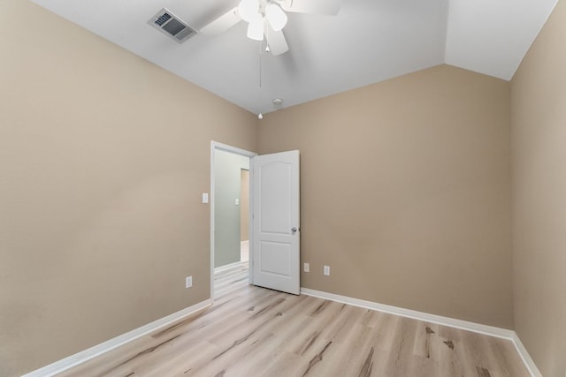 empty room with light wood-type flooring, a ceiling fan, baseboards, and lofted ceiling