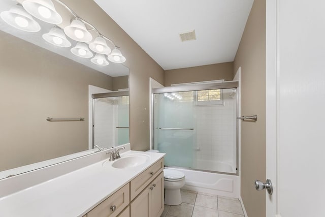 full bathroom with tile patterned floors, toilet, vanity, enclosed tub / shower combo, and baseboards