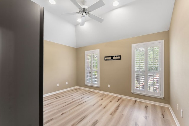 empty room with wood finished floors, ceiling fan, baseboards, high vaulted ceiling, and recessed lighting