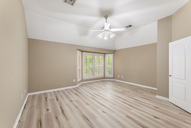 empty room featuring a ceiling fan, light wood finished floors, vaulted ceiling, and baseboards
