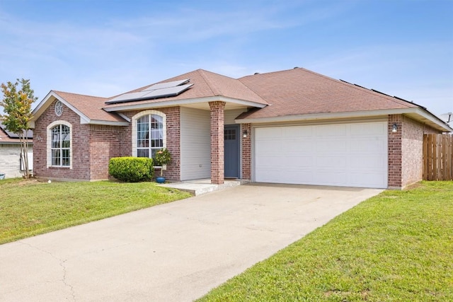 407 Osman Dr, Killeen, TX 76542 - single story home featuring brick siding, roof mounted solar panels, an attached garage, and driveway