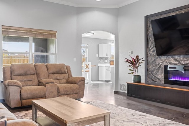 407 Osman Dr, Killeen, TX 76542 - living room with arched walkways, concrete floors, ornamental molding, a glass covered fireplace, and baseboards