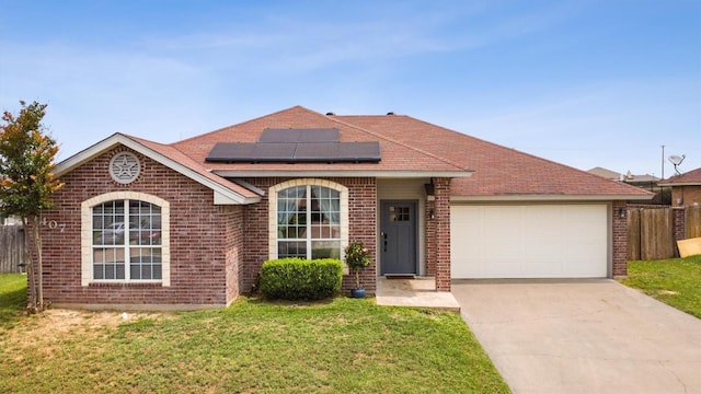 407 Osman Dr, Killeen, TX 76542 - ranch-style home with brick siding, solar panels, an attached garage, and driveway