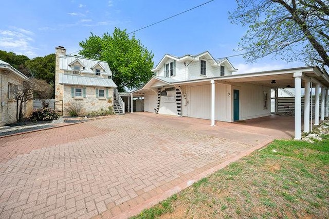 234 Loring, Stonewall, TX 78671 - view of front facade with a chimney, a carport, driveway, and stairway