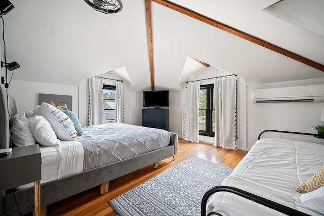 234 Loring, Stonewall, TX 78671 - bedroom featuring an AC wall unit, access to outside, multiple windows, wood finished floors, and vaulted ceiling