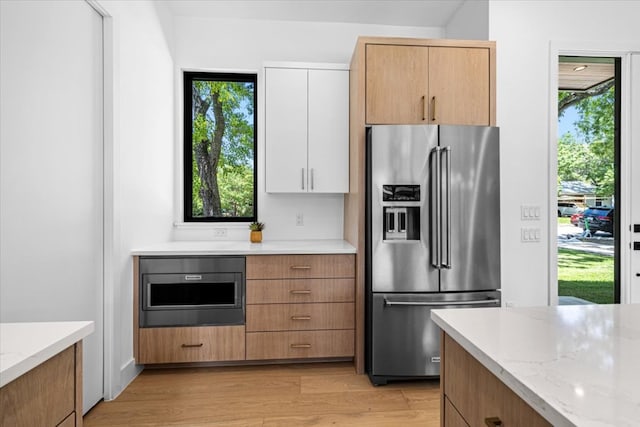5409 Ave G Ave, Austin, TX 78751 - kitchen with high end fridge, light wood-style floors, light stone counters, and healthy amount of natural light