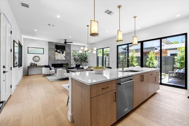 5409 Ave G Ave, Austin, TX 78751 - kitchen featuring a fireplace, stainless steel dishwasher, a large island, light wood-type flooring, and modern cabinets