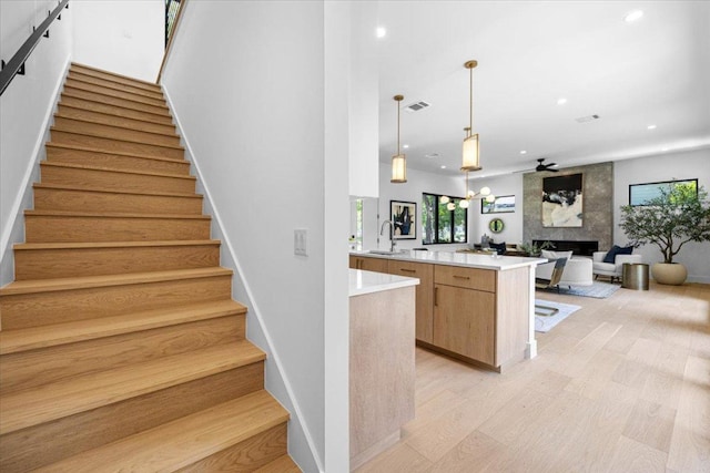 5409 Ave G Ave, Austin, TX 78751 - kitchen featuring a fireplace, recessed lighting, light wood-style flooring, light countertops, and decorative light fixtures
