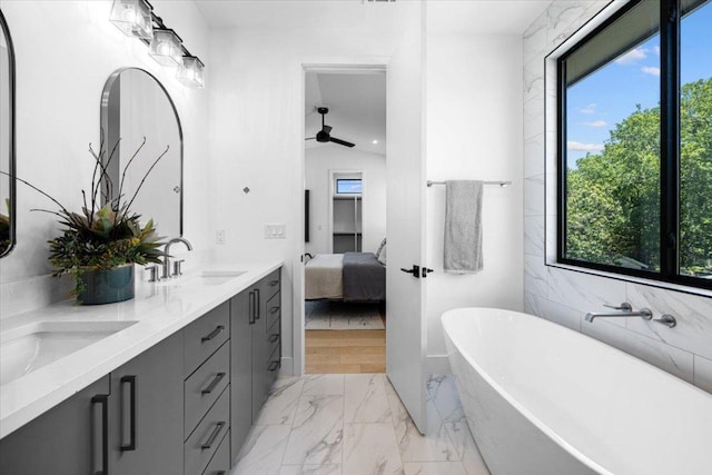 5409 Ave G Ave, Austin, TX 78751 - bathroom with marble finish flooring, a freestanding bath, ceiling fan, double vanity, and ensuite bathroom