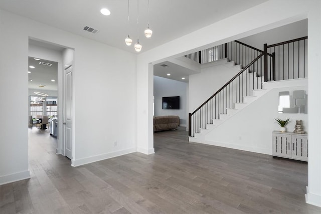 4916 Risana Bnd, Round Rock, TX 78665 - unfurnished living room with wood finished floors, stairway, baseboards, recessed lighting, and a chandelier