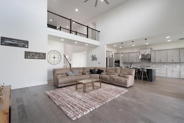 4916 Risana Bnd, Round Rock, TX 78665 - living area featuring wood finished floors, a high ceiling, ceiling fan, recessed lighting, and baseboards