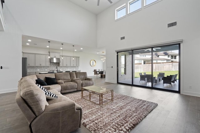 4916 Risana Bnd, Round Rock, TX 78665 - living room featuring ceiling fan, a towering ceiling, wood finished floors, baseboards, and recessed lighting