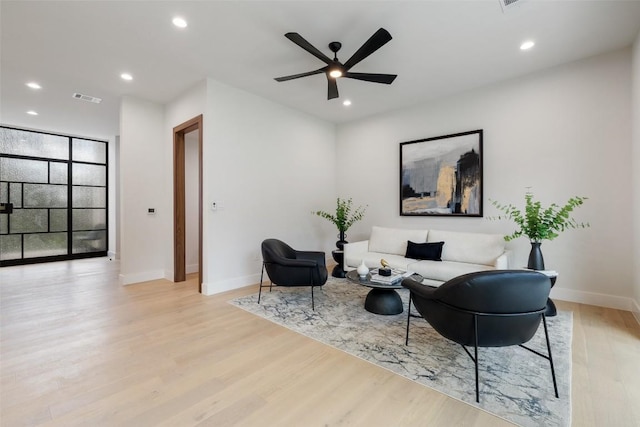 living area with light wood finished floors, ceiling fan, recessed lighting, and baseboards
