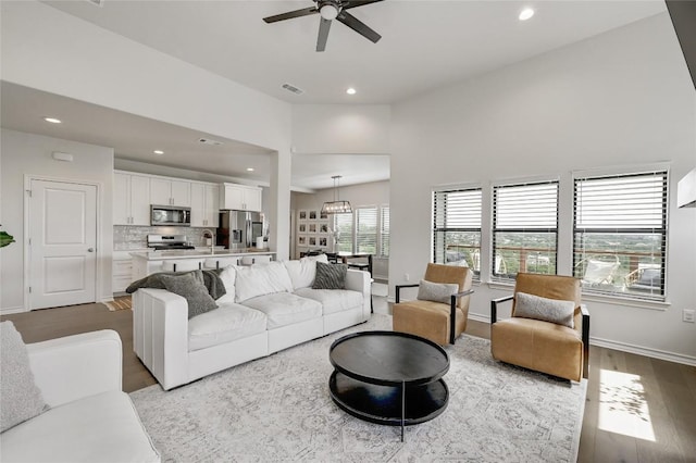 living area featuring a ceiling fan, recessed lighting, wood finished floors, and baseboards