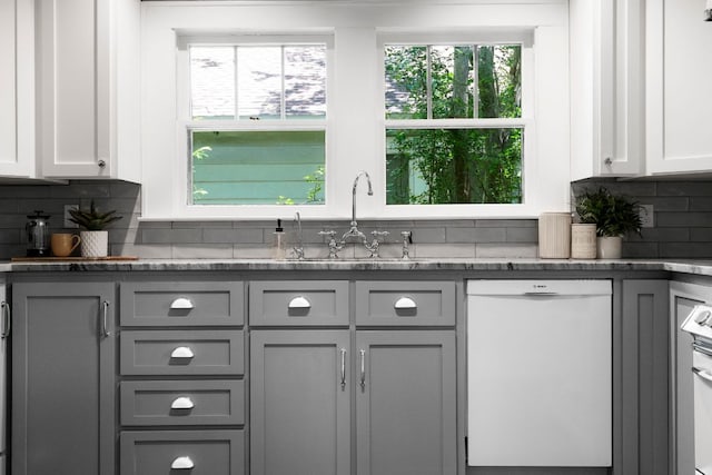 4536 Duval St Unit 2, Austin, TX 78751 - kitchen with dishwasher, gray cabinets, a sink, backsplash, and dark stone counters