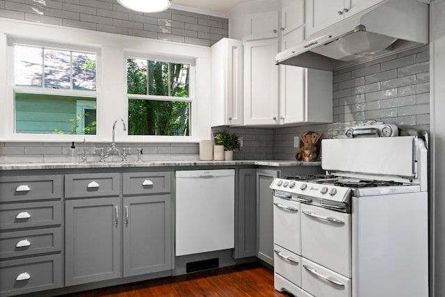 4536 Duval St Unit 2, Austin, TX 78751 - kitchen featuring white appliances, gray cabinetry, under cabinet range hood, backsplash, and dark wood-type flooring