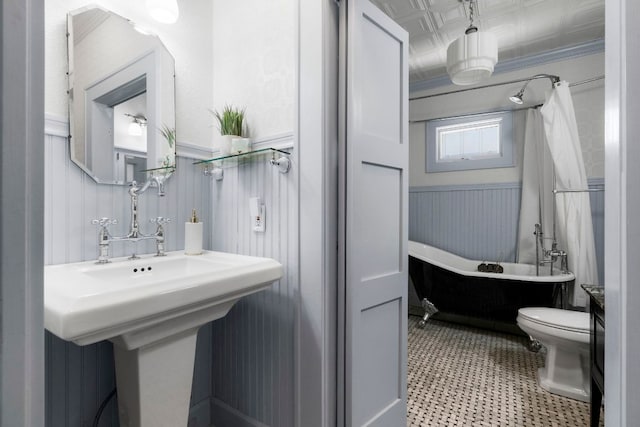 4536 Duval St Unit 2, Austin, TX 78751 - full bathroom with a wainscoted wall, a soaking tub, and toilet