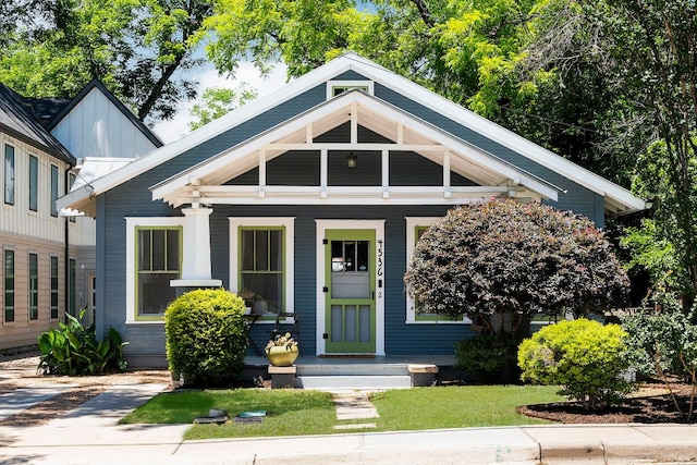 4536 Duval St Unit 2, Austin, TX 78751 - view of front facade with covered porch, board and batten siding, and a front lawn