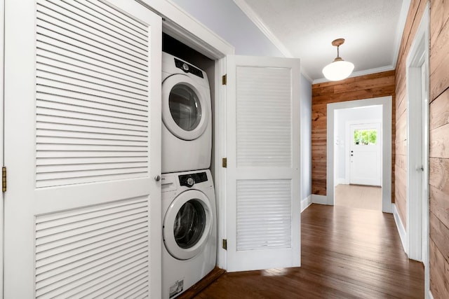 4536 Duval St Unit 2, Austin, TX 78751 - laundry area featuring stacked washer and clothes dryer, ornamental molding, wood finished floors, and wooden walls